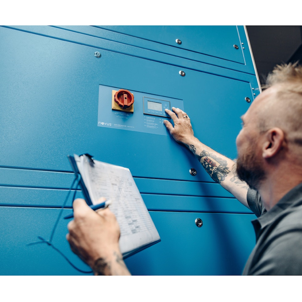 A man with tattooed arm is touching a display