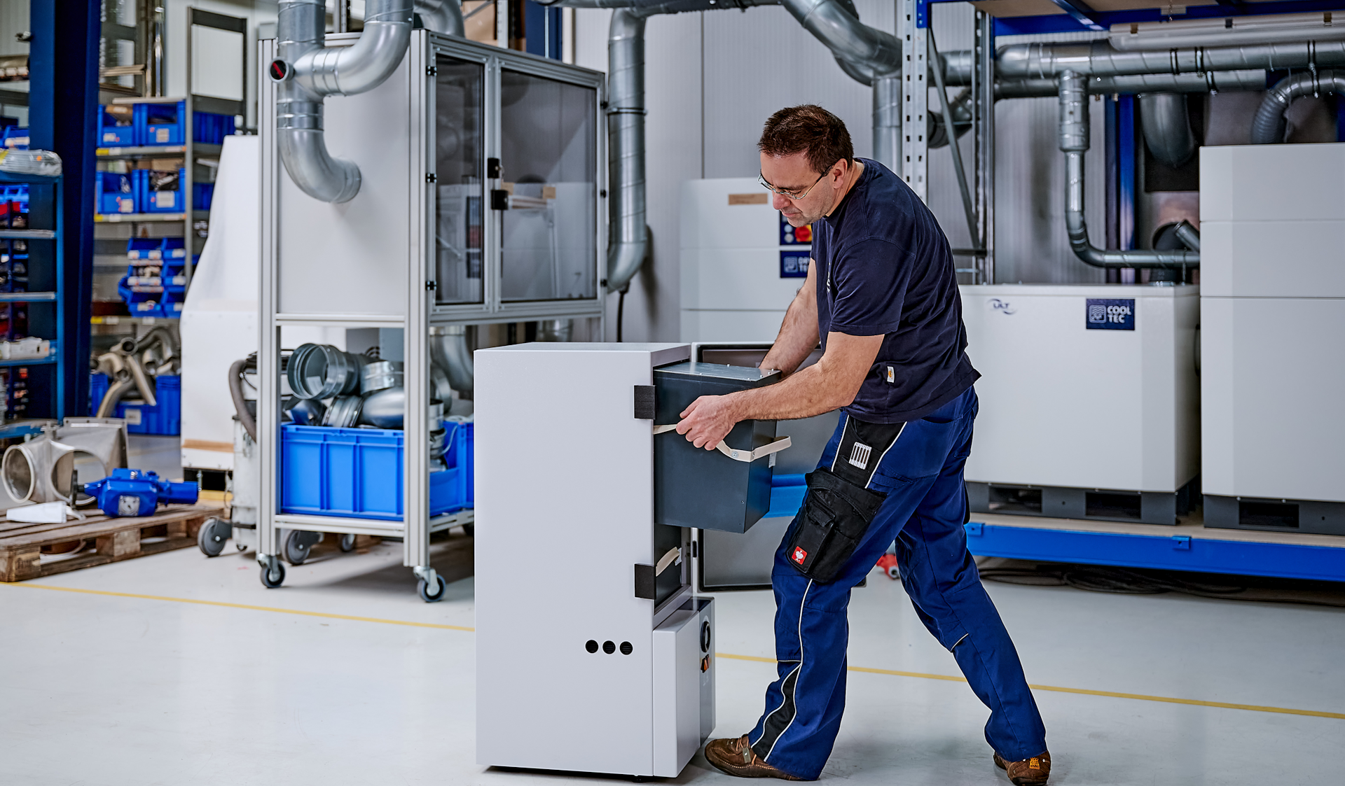 A man pulls a filter module ouf of a fume extraction system