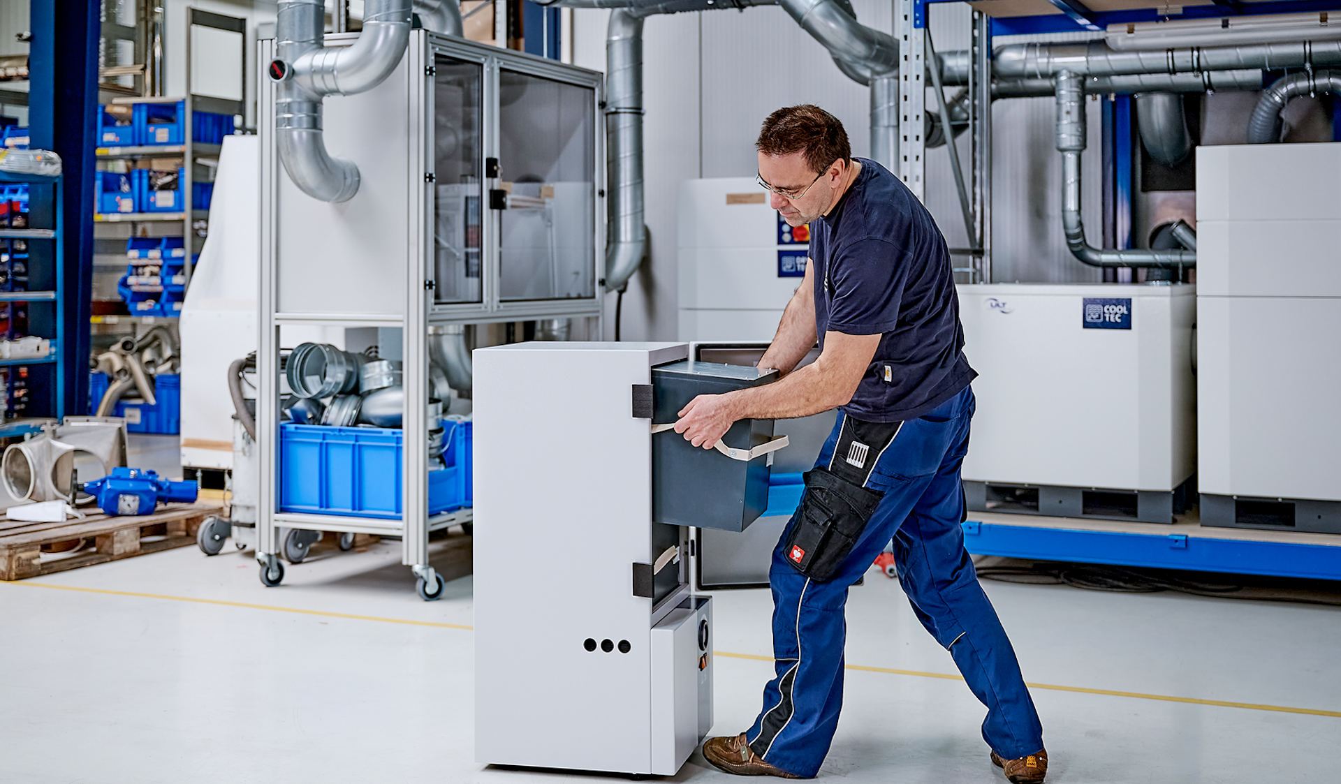 A man pulls a filter module ouf of a fume extraction system