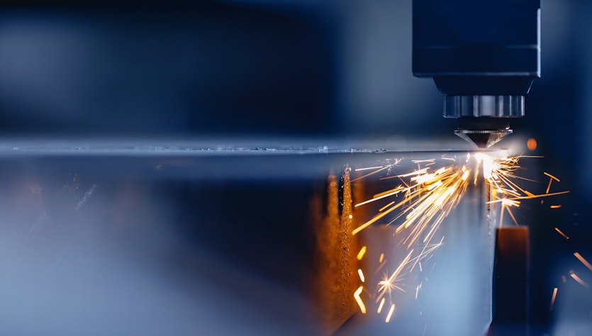 Laser processes material producing sparks and fume
