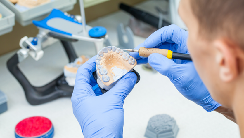 A young man works on artificial teeth