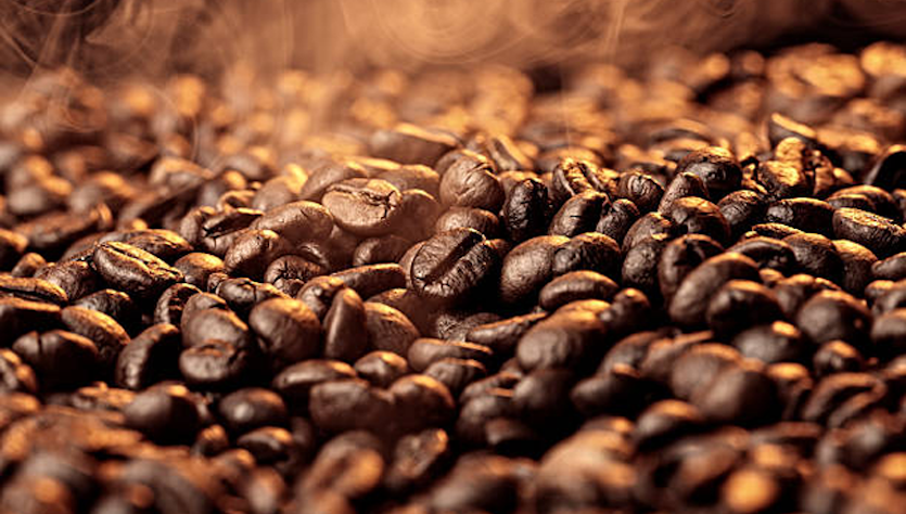 A spoon with orange powder over a bowl